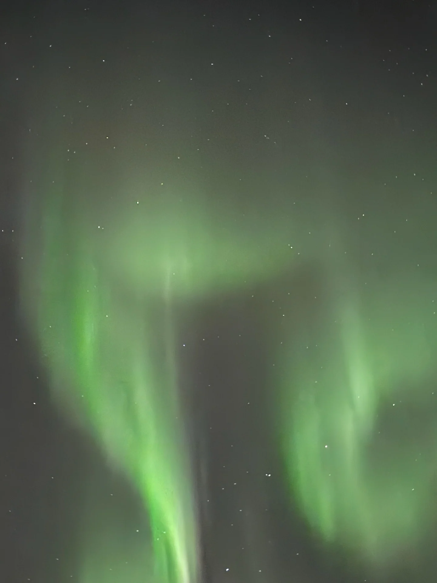 Bright green aurora pillars rising through a starry sky near Rovaniemi