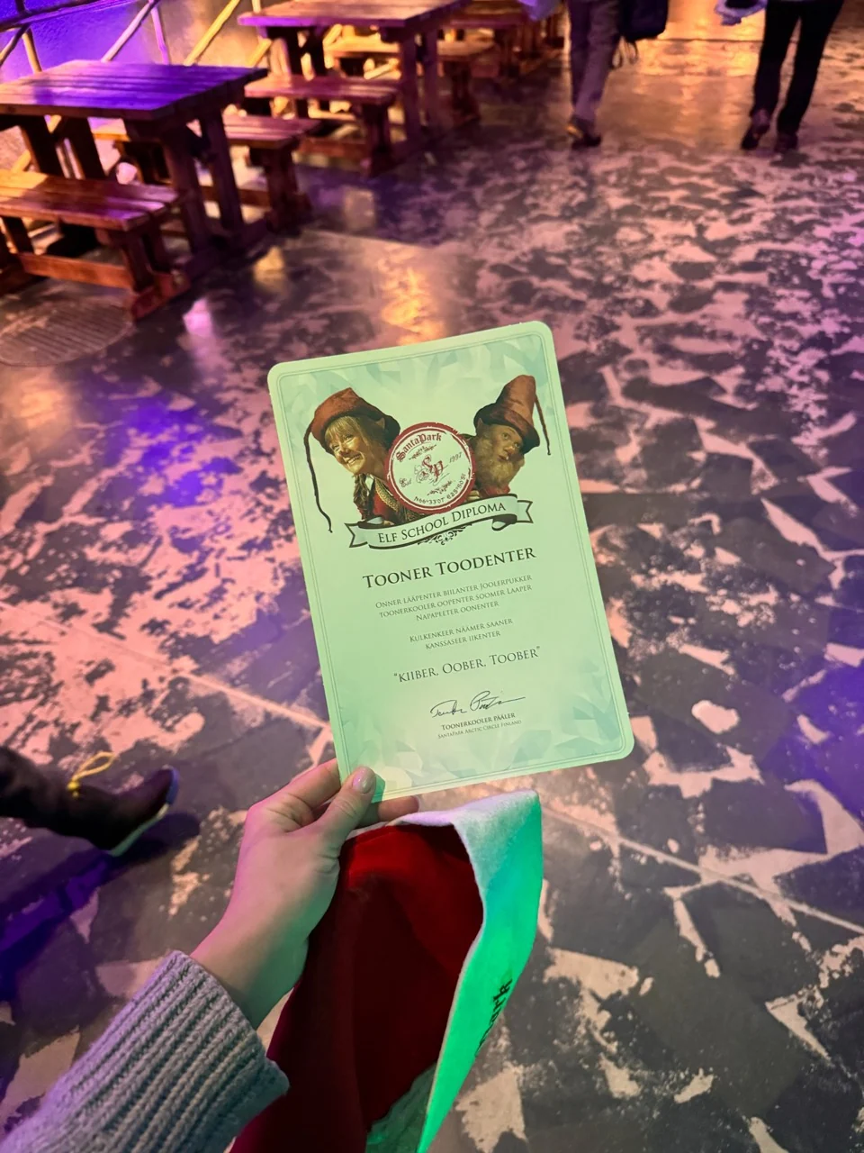 Elf School diploma held inside SantaPark after the class
