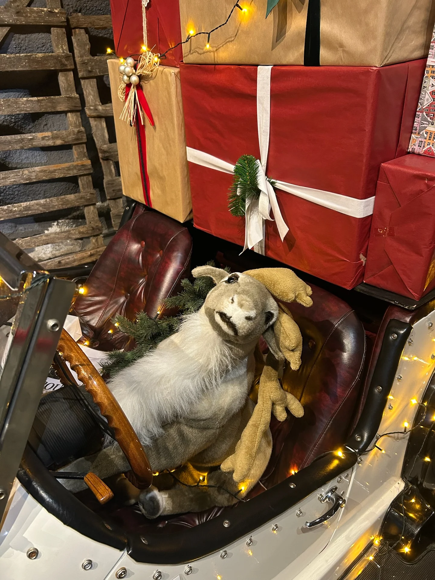 Decorative reindeer figure seated in a small car inside SantaPark