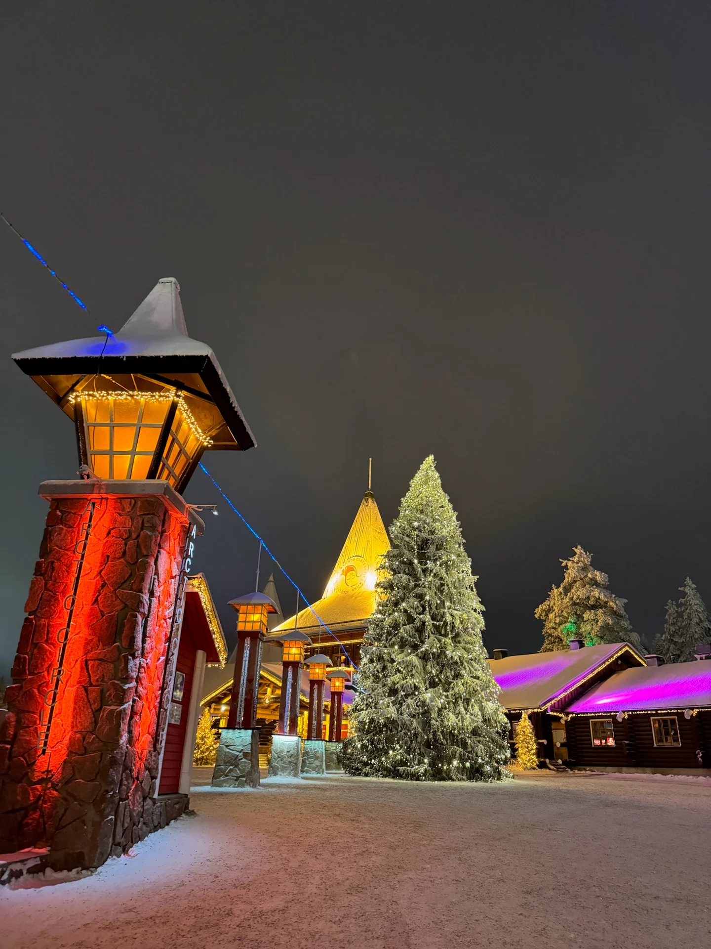Illuminated central square at Santa Claus Village on a snowy night
